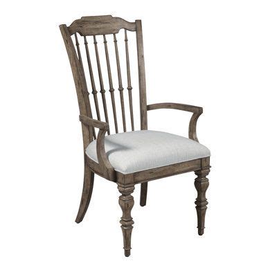 An Old Wooden Chair With White Upholstered Seat And Armrests Against A