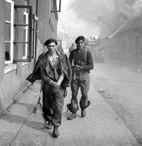 A Canadian Soldier From The 4th Canadian Armoured Division Escorts A Wounded Captured