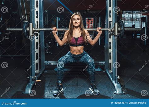 Beautiful Fitness Young Girls Doing Squats With The Barbell In Smith Machine At The Gym Perfect