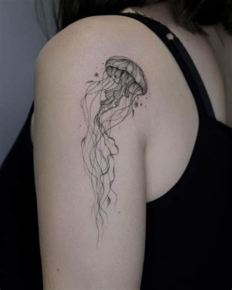 A Black And White Photo Of A Woman S Arm With A Jellyfish Tattoo On It