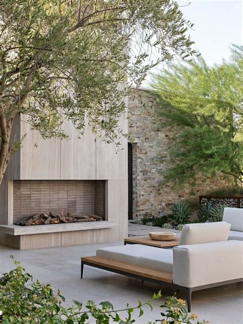 An Outdoor Living Area With Couches And A Fire Place