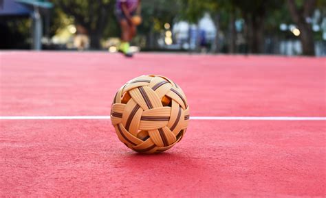 Sepak takraw ball on red floor of outdoor court, blurred background