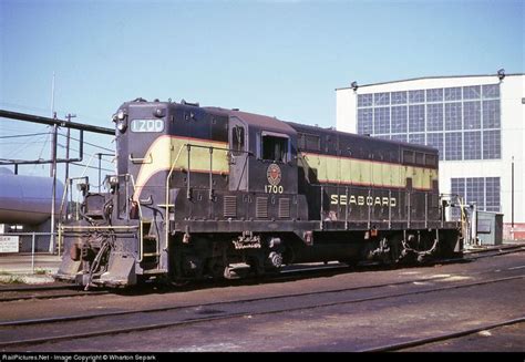 An Old Train Sitting On The Tracks In Front Of A Building