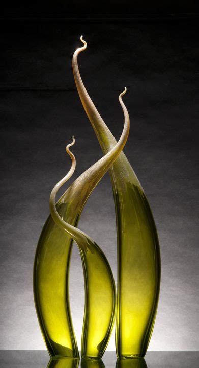 Two Green Glass Vases Sitting On Top Of A Black Table Next To Each Other