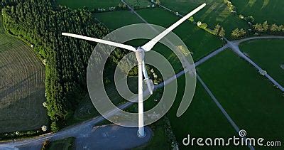 Large Wind Turbine With Blades On Green Field Aerial View Of Green