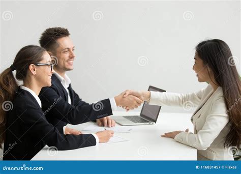 Smiling Female Applicant Greeting Hr Managers With Handshake Stock