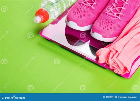 Zapatillas De Deporte Rosadas Del Deporte Y Un Chaleco En Las Escalas