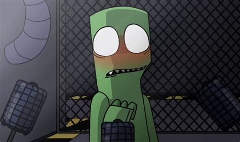 A Green Cartoon Character With Big Eyes Standing In Front Of A Caged