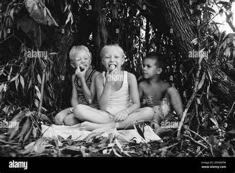 Three Children Play In A Hut Which They Themselves Have Built From