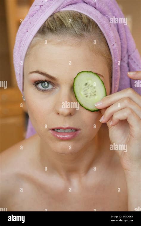 Blonde Frau Haelt Gurkenscheibe Vor Das Auge Stock Photo Alamy