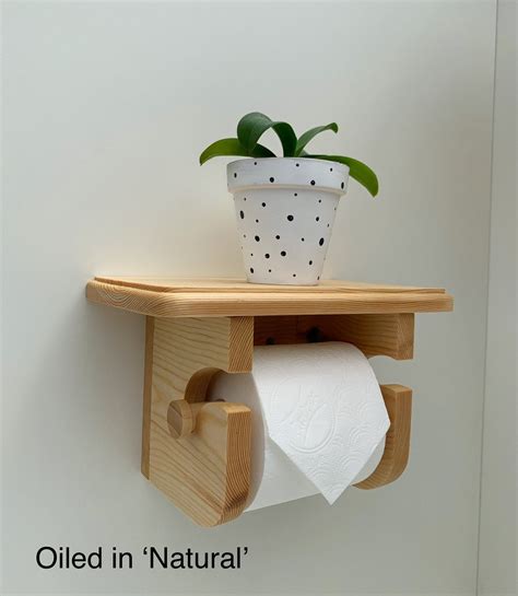 A Potted Plant Sitting On Top Of A Wooden Shelf Next To A Roll Of