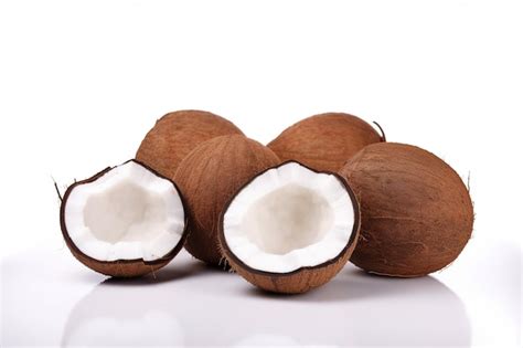 Un Coco Entero Y Medio Sobre Una Superficie Blanca Foto Premium