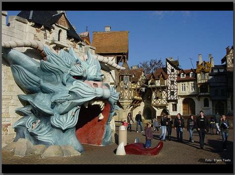 People Are Walking In Front Of An Elaborately Carved Dragon Head On The