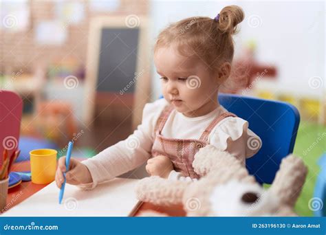 Adorable Caucasian Girl Preschool Student Sitting On Table Drawing On