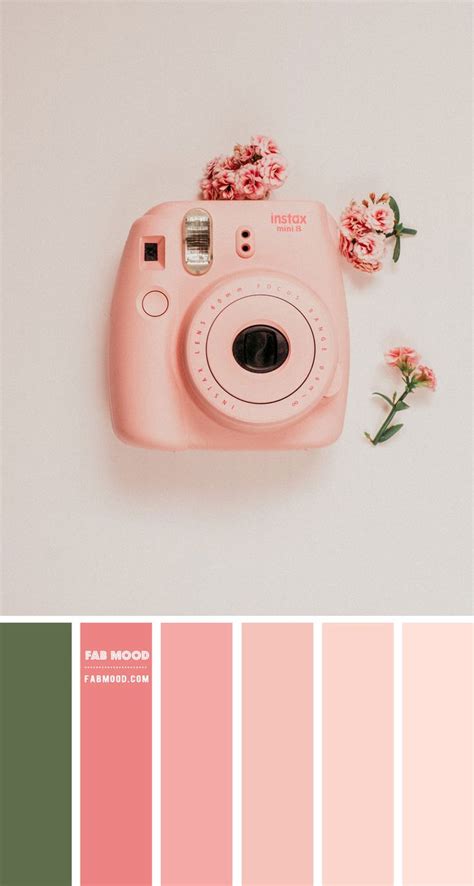 a pink camera sitting on top of a table next to flowers