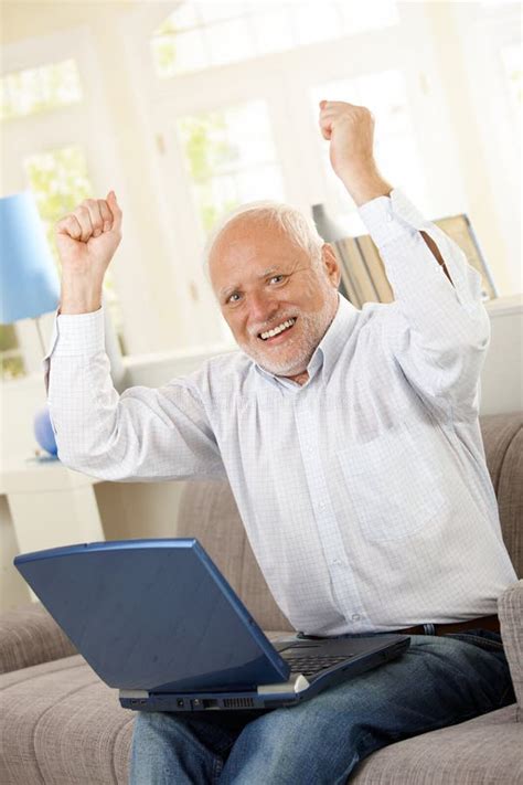 Homem Idoso Feliz Que Senta se No Sofá Portátil Foto de Stock