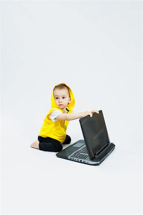 Premium Photo | A cheerful 1yearold boy in a yellow vest sits with a