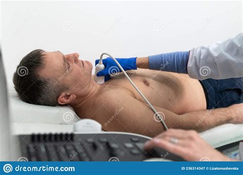 Doctor Using Ultrasound Machine To Scan Heart Of A Male Patient