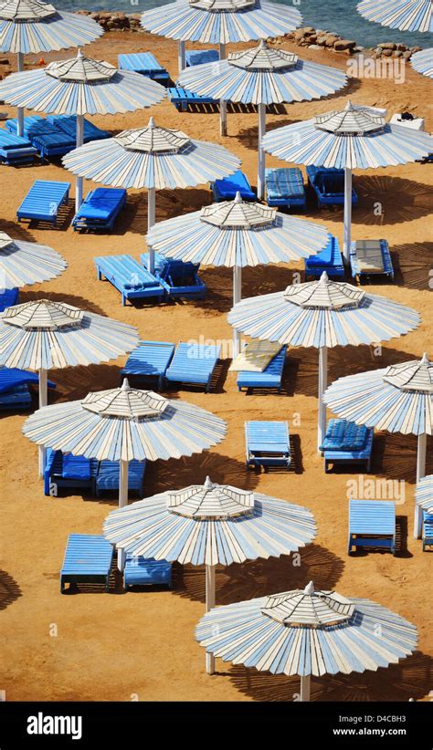 Sombrilla de playa arena mar verano caliente fotografías e imágenes de