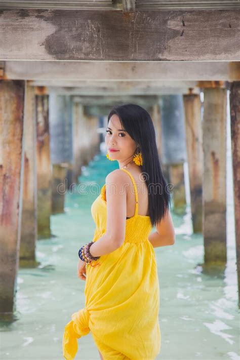 Portrait Beautiful Asian Woman In A Yellow Dress Standing Under The