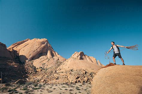 Mountain Climber Throwing Rope By Stocksy Contributor Juno Stocksy