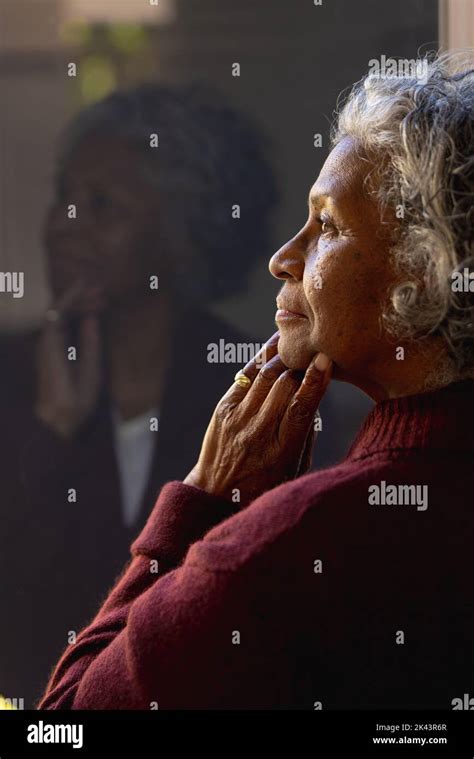 Thoughtful Senior African American Women Looking Out The Sunny Window