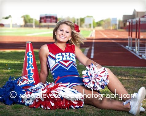 A Cheerleader Sitting On The Ground With Her Pom Poms In Front Of Her