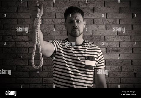 Depressed Man With Rope Noose Near Brick Wall Suicide Concept Stock