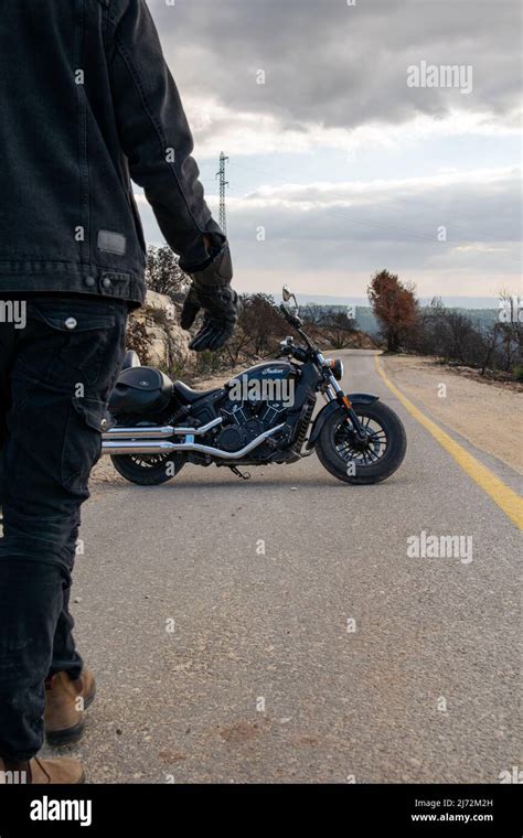 Young Man Carrying Motorcycle Helmet Walking To His Motor Bike Stock