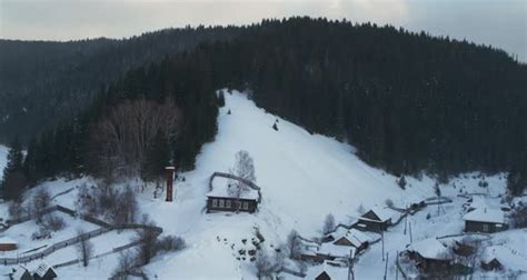 Aerial View Of Wooden Houses In A Village Between Two Hills In Winter