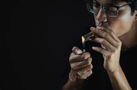 Premium Photo Close Up Of Man Smoking Electronic Cigarette Against