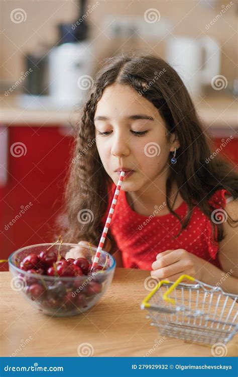 Teenage Girl Drinks Juice From A Cherry In A Plate Through A Straw The