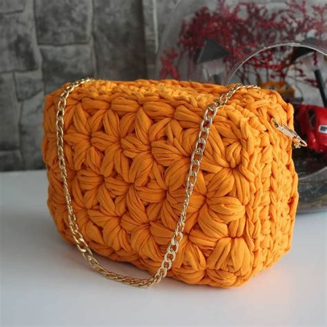 An Orange Crocheted Purse Sitting On Top Of A Table