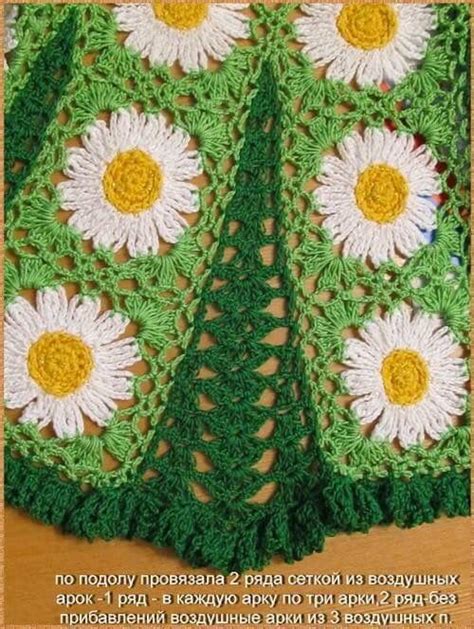 A Crocheted Green And White Afghan With Flowers In The Center On Top