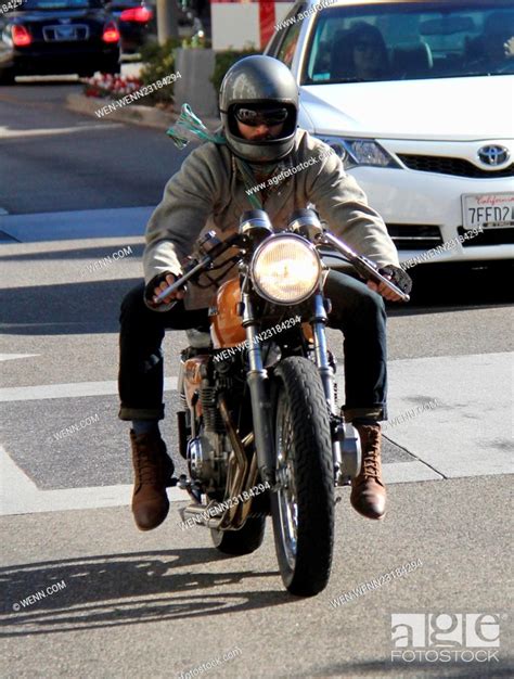 Keanu Reeves riding his motorbike with a silk scarf flying in the wind ...