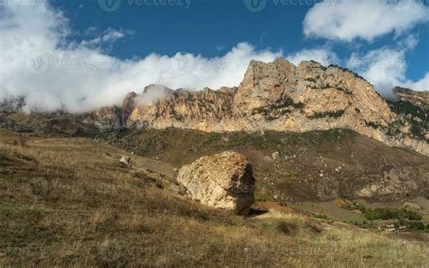 Beautiful autumn mountain landscape with giant granite stone among on hill and mountains ...