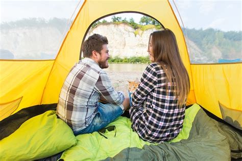 Premium Photo | People, summer tourism and nature concept - young couple resting in camping tent ...