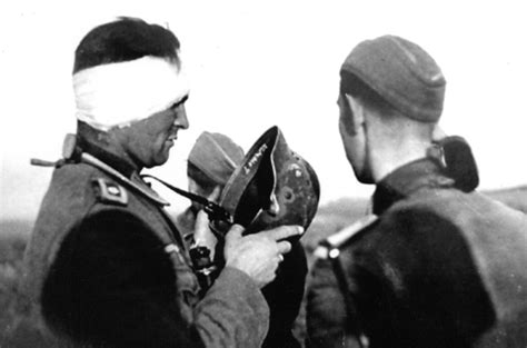 Немецкий фельдфебель демонстрирует каску, спасшую его жизнь — военное фото