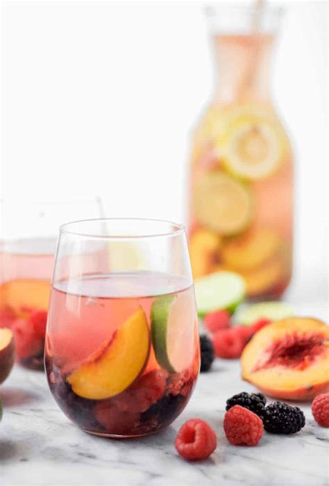 White Wine Sangria In A Wine Glass On A Marble Board With A Peach Half