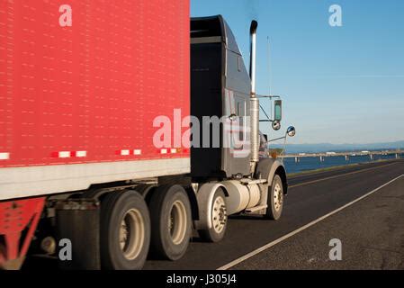 Wide Multilane Highway With Semi Truck And Cars And Concrete Dividing