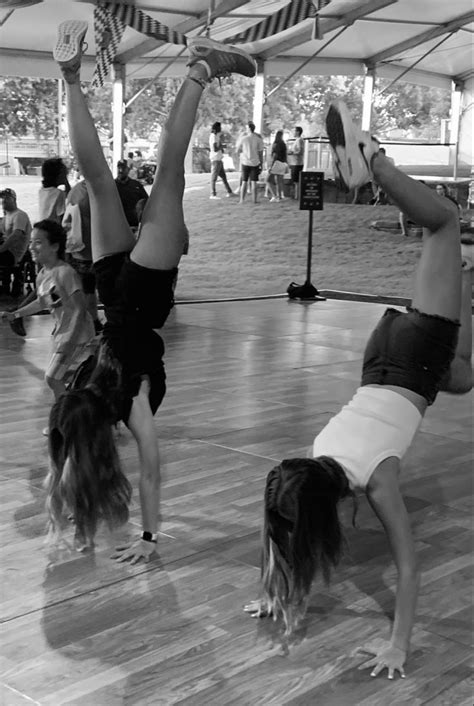 Two Women Doing Handstands On The Floor While Others Watch