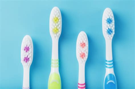 Premium Photo Toothbrushes Of Different Colors In A Row On A Blue Surface