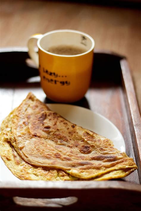 There Is A Plate With Some Food On It And A Cup Of Coffee Next To It