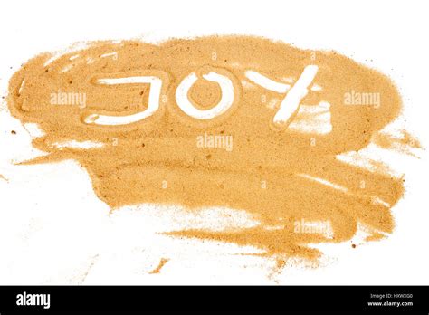 Word JOY Written On Pile Of Yellow Sand Isolated On White Background