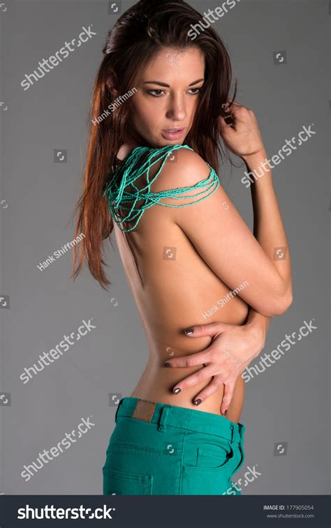 Pretty Slender Brunette Topless Teal Jeans Stock Photo