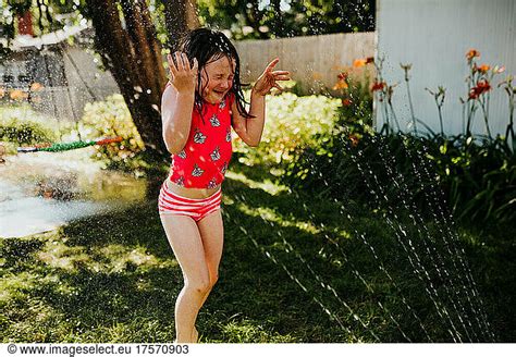 Close Up Of Young Girl Getting Sprayed In The Face By A Sprinkler Close