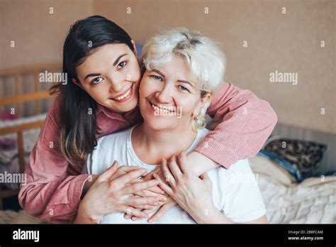 Belle mère blonde mûre et sa fille de brunet adulte embrassent Photo Stock Alamy