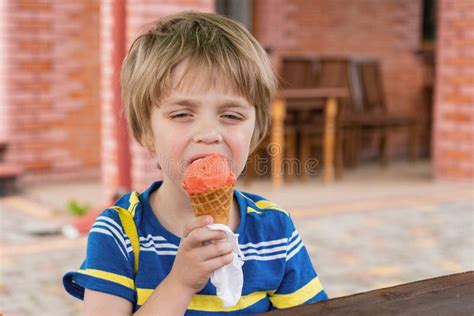 The Boy Eats Ice Cream He Narrowed His Eyes In Pleasure Stock Photo