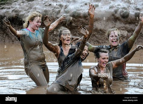 Mud Covered Women Competitors Celebrate Finishing Race Waist Deep In