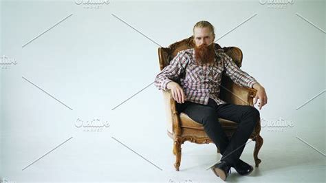 Bearded Man Sitting Luxury Armchair And Looking Into Camera On White Background Luxury Arm